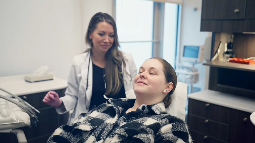 A patient relaxed in the chair while her dentist talks to her at Brightside Dental